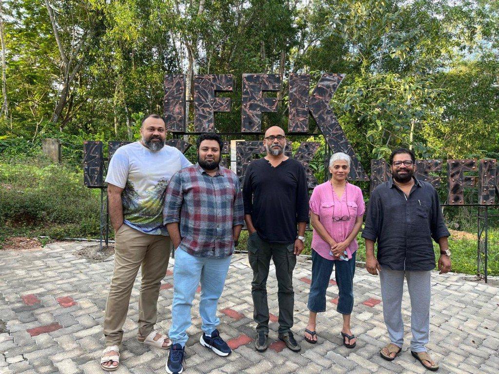 O.P. Suresh standing with four other people in front of large letters spelling IFFK.