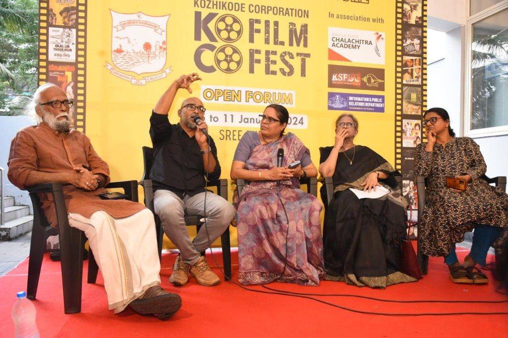 O.P. Suresh speaking at the Kozhikode Corporation KO Film Fest open forum. The banner includes the Kerala State Chalachitra Academy and the date to 11 January 2024.
