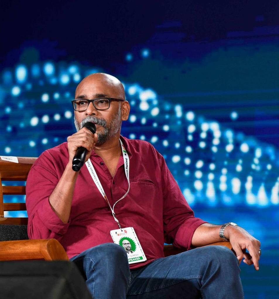 O.P. Suresh speaking at the Wayanad Literature Festival. His badge reads O.P. Suresh, Speaker.